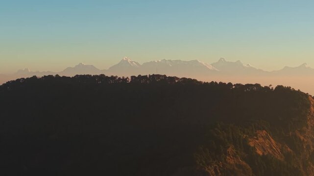 4K panoramic aerial footage of Uttarakhand Himalayan peaks glowing in warm sunrise light with scenic mountain skyline.