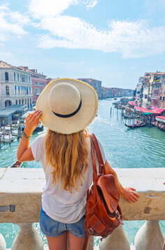 Woman with straw hat looking at grand canal from rialto bridge in venice, Tour tourism in Italy, Travel destination in Europe