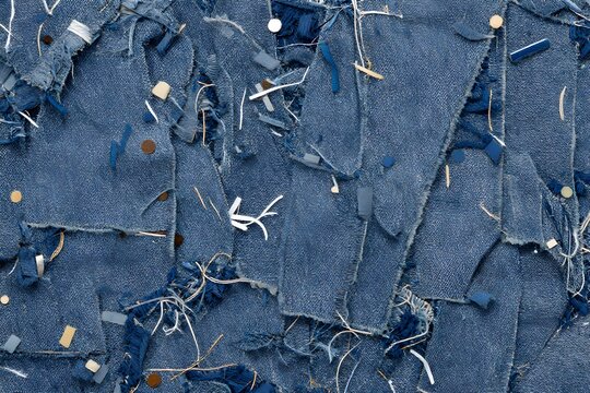 Denim fabric patchwork, abstract texture of frayed indigo cloth and lint.