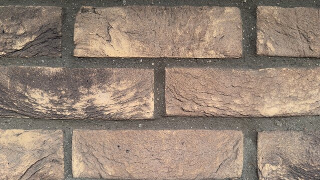 Macro yellow clinker brick texture background, detailed ochre and brown brickwork close up