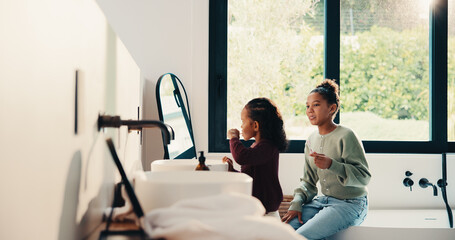 Obraz premium Bathroom, brushing teeth and sister kids in home together for morning routine to oral health. Cleaning, dental hygiene and toothbrush with girl children in apartment for tooth care as siblings