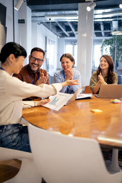Business team applauding successful presentation in modern office meeting discussing achievement