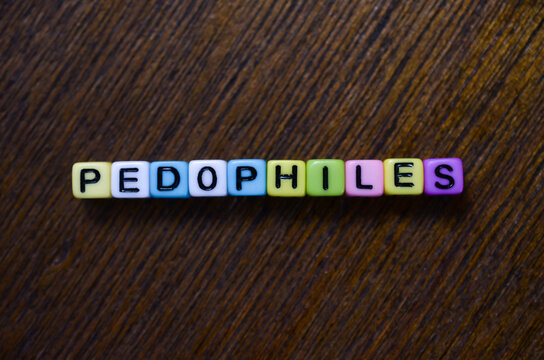 Word pedophiles spelled with colorful letter beads on wood