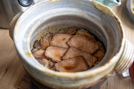 Traditional Japanese pork kamameshi cooked in a clay pot at a hot spring town restaurant in Yufuin, Kyushu