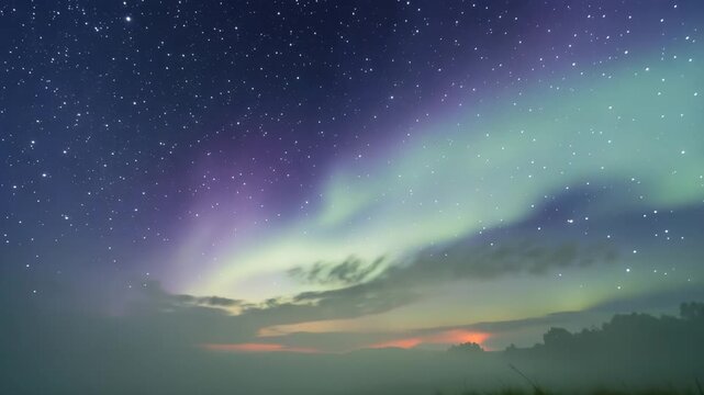 Stunning aurora borealis lights illuminating starry night sky with clouds and distant landscape 4k video