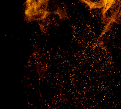 Golden particles swirl against a deep black void