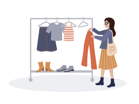 Sustainable fashion, woman choosing clothes from the rack in second hand shop or thrift store.
