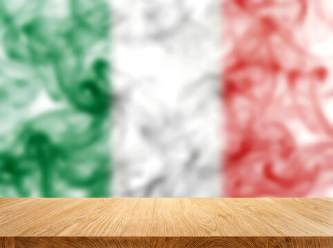 Empty wooden table surface with blurred Italian flag smoke background for product placement and food advertising display