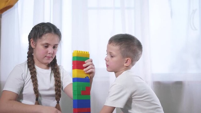 Two lifestyle children playing with blocks. A group of children are assembling a construction. A group of kids play with toys. Two kids stacking blocks.