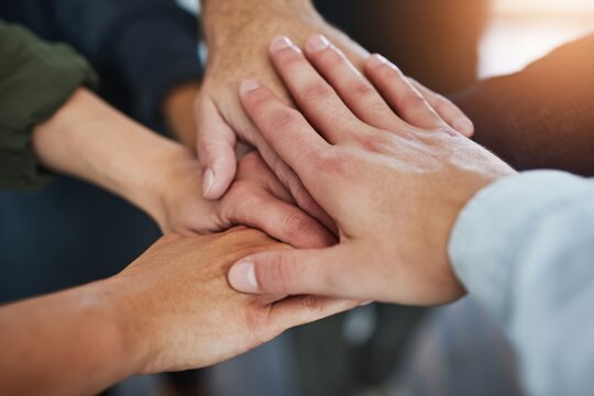 The hands of a diverse team coming together in unity and collaboration