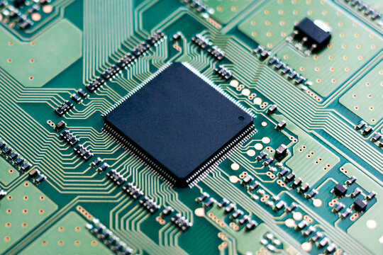 Macro close-up of a semiconductor microchip mounted on a circuit board, representing AI computing, electronics engineering, and modern digital technology