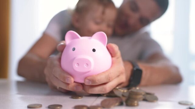 Child is playing with piggy bank full of coins. kid finance father concept. family with baby in a bank with piggy bank. a family lifestyle with a baby and coins in a bank.