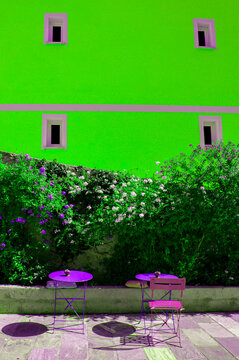 Corsica, France, Europe: graphic reworking in fluorescent colours of outdoor bar tables and the facade of a palace