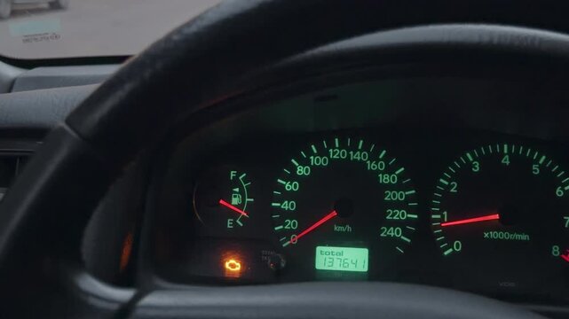 Amber light flashes on dashboard. Amber warning indicator and needle visible on dashboard at dusk
