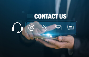 Fototapeta premium Contact us, Businessman hand using smartphone with customer service graphic, Concept of online helpdesk support, digital communication network, corporate business hotline and client assistance center