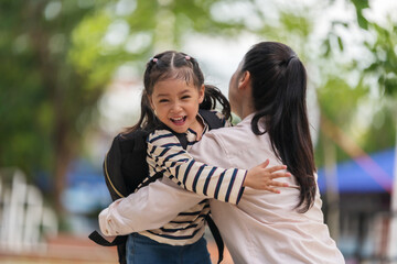 Fototapeta premium mother hugging her little daughter tightly after picking her up from school