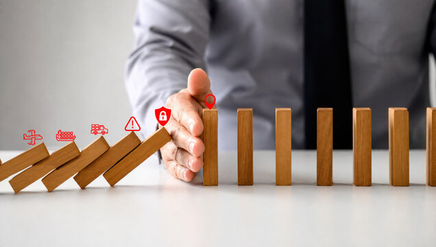 supply chain management logistics risk management. Hand stopping falling dominoes with security icons representing risk management and protection.