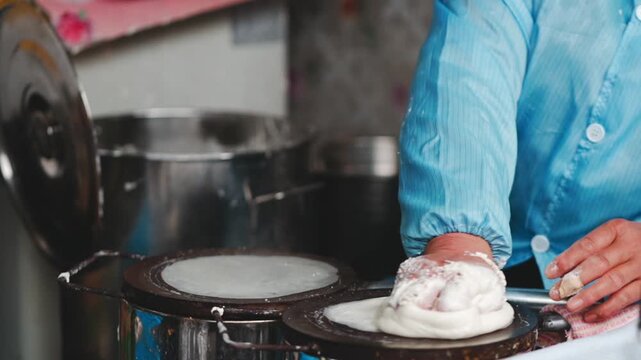 Street Food Vendor Cooking Thin Pancakes on Hot Griddles