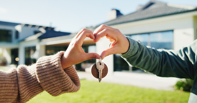 Couple, key and moving in backyard with heart hands, bonding and real estate purchase of new home. Outdoor, married people and keychain with love sign, relocation success or property investment goals