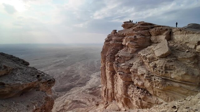 Stunning aerial view capturing the edge of the world escarpment at sunset, highlighting the dramatic cliffs of the Tuwaiq mountain range in Riyadh, Saudi Arabia