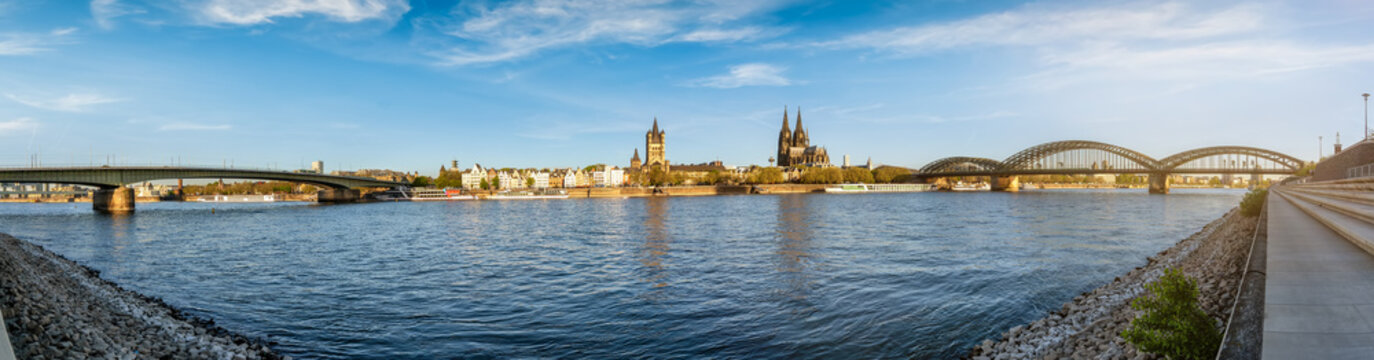 Panoramic sunrise view of the skyline of Cologne, Germany, stretching from Deutzer Bridge and the old town with Cathedral along the River Rhine to the east with Hohenzollern bridge