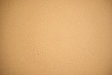 Blank beige painted wall showing textured surface and simple solid color background for design...