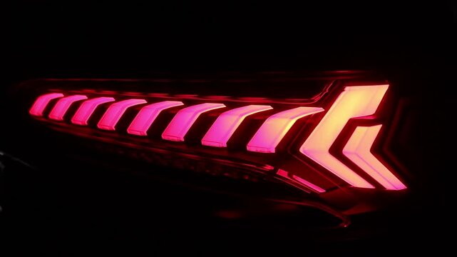 Close up detail on one of the LED red taillight modern crossover car. Rear LED lights closeup of electric hybrid SUV, stylish exterior design of car. Headlight, taillight, car, brake, led light.