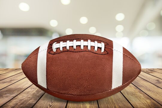 American football ball on desk with mall background