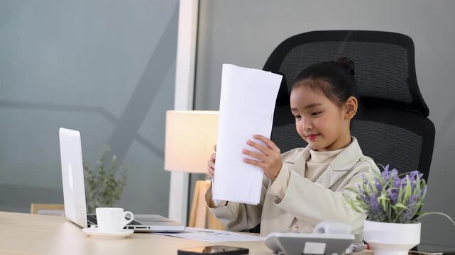 Young Asian Girl in Business Suit Reviewing Documents at Office Desk