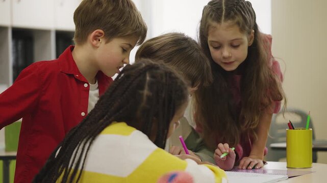 Clever elementary school students brainstorming ideas while working on project