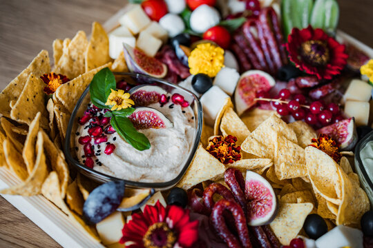 Gourmet charcuterie board with assorted cheeses, cured meats, fresh fruit, crackers, and snacks. Elegant catering platter for weddings, parties, celebrations, and social gatherings.