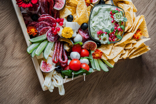 Gourmet charcuterie board with assorted cheeses, cured meats, fresh fruit, crackers, and snacks. Elegant catering platter for weddings, parties, celebrations, and social gatherings.