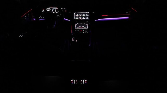 Hybrid electric car Interior view in the cabin. Black leather cockpit with ambient light. Car interior from driver seat view. Cockpit with exclusive decoration. Touch panel climate control