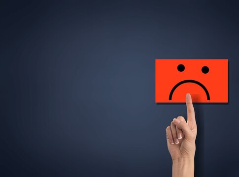 Hand of client show a feedback with bad smile face card. Service rating, satisfaction concept