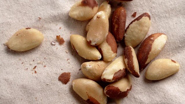 Hand taking a handful of Brazil nuts from fabric background