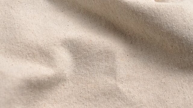 Beige linen fabric texture background with soft folds. Natural light cotton surface with elegant waves and shadows. Rotation