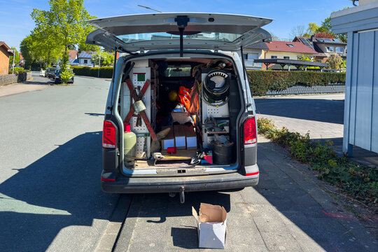 Work van with tools and equipment visible parked on a street