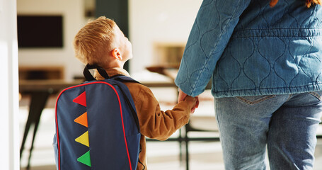 Mother, child and holding hands in home with backpack, support or getting ready for preschool education. Back, mom and boy in lounge with bag, leaving and morning routine for learning at ECD academy. © peopleimages.com