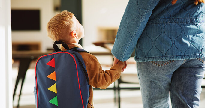 Mother, child and holding hands in home with backpack, support or getting ready for preschool education. Back, mom and boy in lounge with bag, leaving and morning routine for learning at ECD academy.