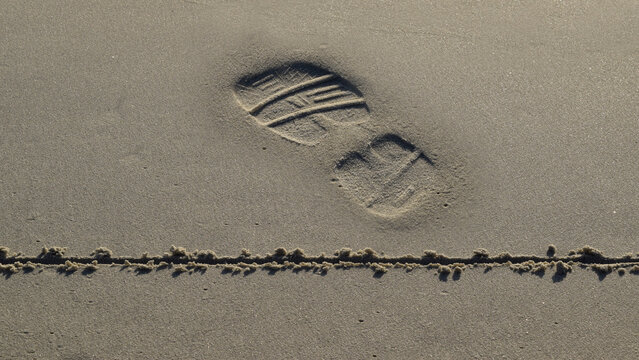 Footprint having crossed over a line in the sand 