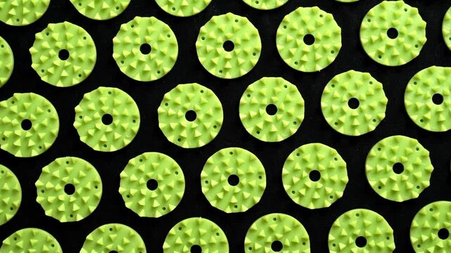 Acupuncture massage mat texture with green lotus spikes. Top view geometric pattern of an acupressure accessory. Rotation