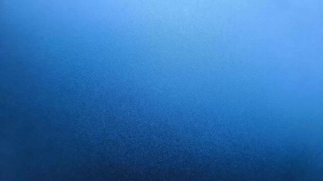 Lite and dark blue colour grainy or granular texture fast flipping motion. Shiny blue surface abstract background for graphic design.