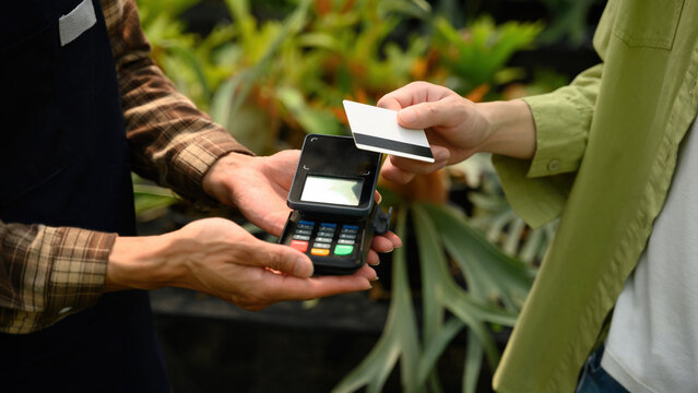 Cropped Shot of Customer Using Credit Card Payment via EDC Machine at SME Plant Nursery Garden Shop