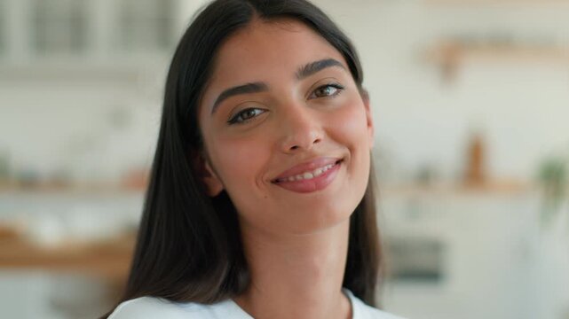 Happy playful Arabian Indian woman at home apartment looking at camera smiling showing tongue laughing funny grimace joyful mood attractive ethnic female having fun cheerful girl indoors cute portrait