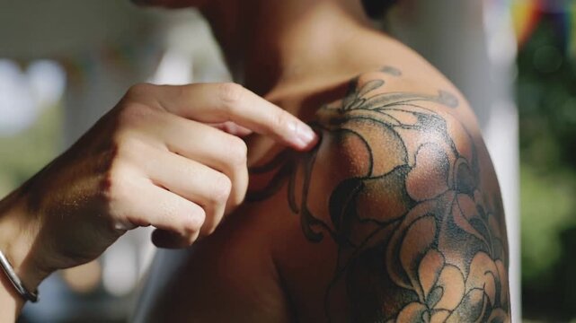 Pressing hand coming tracing floral tattoo on bare shoulder feeling ink in porch bangle