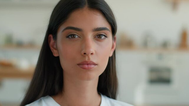 Serious calm Indian woman at home apartment looking at camera upset worried problem mortgage insurance female businesswoman homeowner negative emotion Arabian girl lady stress anxiety thinking trouble