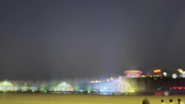 defocus colorful night fountain lights illuminate taian with vibrant water display.