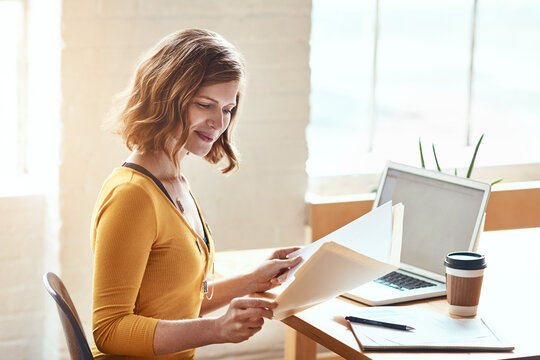 Business woman, checking documents or laptop with folder for financial planning or budget in office. Female person, accountant or reading with paperwork for company expenses or finance in workplace