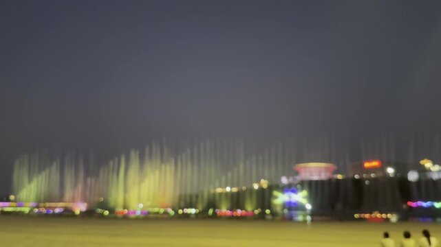defocus colorful night fountain lights illuminate taian with vibrant water display.