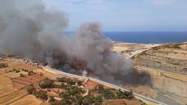 In Maghtab, Malta, firefighters and emergency vehicles respond to a landfill fire sending toxic smoke over the waste site in an aerial view of the hazardous incident on May 6th, 2026.